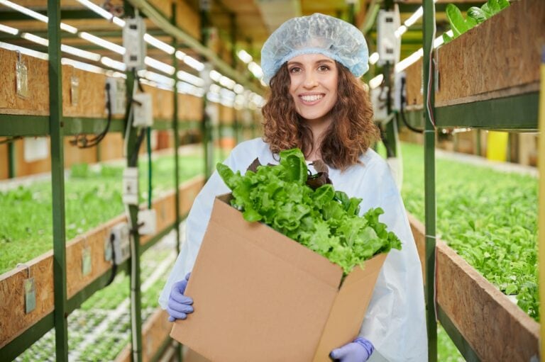 Cheerful Woman Holding Box With Fresh Leafy Greens.